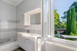 a bathroom with a sink and a mirror and a window at Domaine De La Perthuiserie in Saint-Porchaire +50 photos