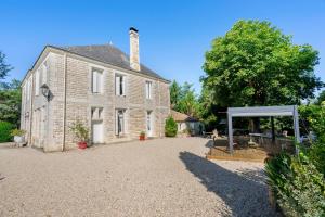 an old stone house with a pavilion in front of it at Domaine De La Perthuiserie in Saint-Porchaire