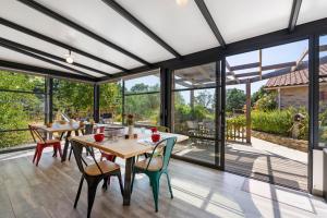 a conservatory with tables and chairs and large windows at Le Cocon Vendéen Chambres D'hôtes in Saint-André-Goule-dʼOie
