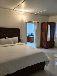 a bedroom with a large bed and a bathroom at Spring Grove B&B in Jowai