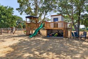 a playground with a tree house and a slide at Le Cocon Vendéen Chambres D'hôtes in Saint-André-Goule-dʼOie