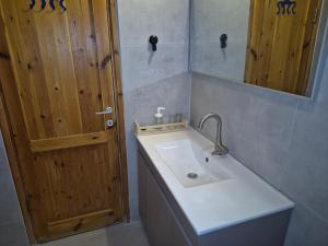 a bathroom with a sink and a wooden door at Ronit and Mario in Abirim