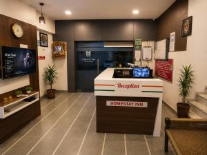 a restaurant with a kitchen with a counter in a room at Home Stay Inn 5 min from Sardar Vallabhbhai Patel International Airport Ahmedabad in Ahmedabad