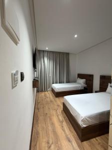 a hotel room with two beds and a window at Nezha Hotel in Tangier