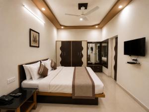 a bedroom with a large bed and a television at Home Stay Inn 5 min from Sardar Vallabhbhai Patel International Airport Ahmedabad in Ahmedabad