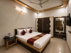 a bedroom with a large bed and a table and a television at Home Stay Inn 5 min from Sardar Vallabhbhai Patel International Airport Ahmedabad in Ahmedabad +66 photos