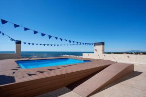 a swimming pool on top of a building with the ocean at Apartamento Pepi in L'Ametlla de Mar