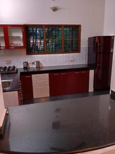 a kitchen with a black counter top and a refrigerator at Aanchal Nest in Mangalore