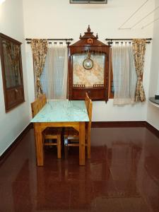 a dining room with a table and a grandfather clock at Aanchal Nest in Mangalore