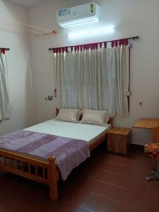 a bedroom with a bed and a window with at Aanchal Nest in Mangalore