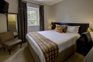 a bedroom with a bed and a chair and a window at Forest Lodge Hotel in Lyndhurst +89 photos