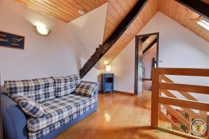 a living room with a couch and a wooden ceiling at Les hauts de kergiquel in Paimpol
