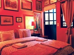 a red bedroom with a bed with towels on it at Gallery Basement in Villa Vravrona in Markopoulo