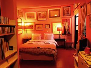 a bedroom with a bed, desk, lamp, and bookshelf at Gallery Basement in Villa Vravrona in Markopoulo