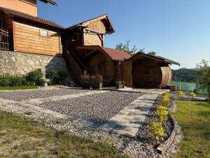a house with a stone walkway in front of a building at Glamping Medvedjek - Nočitev v vinskem sodu in Velika Loka