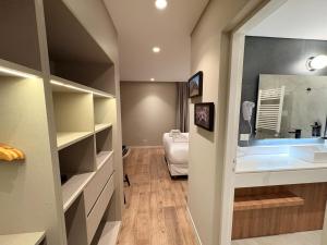 a room with a bathroom with a sink and a bed at Origen Patagonia Hotel in Puerto San Julián