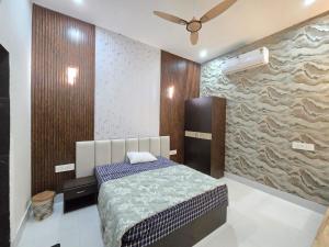 a bedroom with a bed and a stone wall at The Pool place and Restaurant in Bagar Meo
