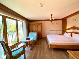 ein Schlafzimmer mit Bett und Balkon in der Unterkunft Hotel Bärenstüberl in Schönau am Königssee + 86 Fotos