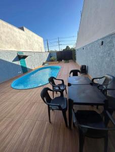 a patio with chairs and a table and a swimming pool at Área de Lazer DAY USE - Chácara do Danilo in Maringá +16 photos