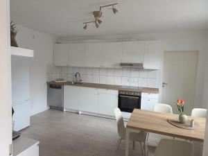 a kitchen with white cabinets and a table and chairs at Ferienwohnung Nele in Heimbach