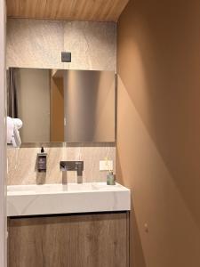 a bathroom with a sink and a mirror at Origen Patagonia Hotel in Puerto San Julián +4 photos