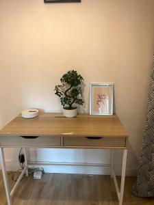 a wooden desk with a picture and a plant on it at Appartement familial RDC in Boulogne-Billancourt