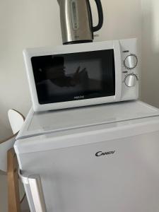 a microwave sitting on top of a refrigerator at Appartement familial RDC in Boulogne-Billancourt +4 photos