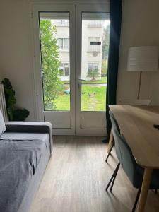 a bedroom with a bed and a desk and a window at Appartement familial RDC in Boulogne-Billancourt