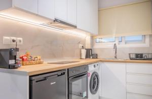 a kitchen with white cabinets and a dishwasher at Rafaela Sea Gem in Loutraki