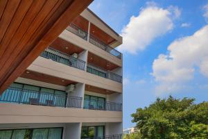 an apartment building with balconies and a tree at The BELL in Nai Yang Beach