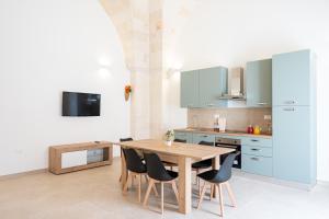 a kitchen with a wooden table and chairs at Le Volte in Lizzano