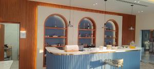 a kitchen with a counter with arched windows at Al-TARABOT HOTEL in Muscat