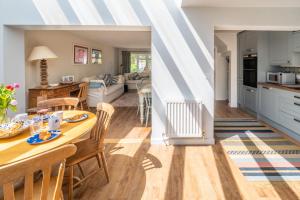 a kitchen and living room with a table and chairs at Little Tern in Brancaster