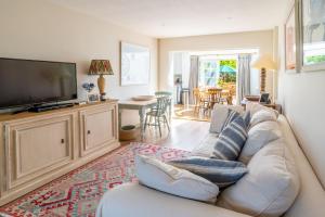 a living room with a couch and a flat screen tv at Little Tern in Brancaster