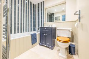 a bathroom with a toilet and a tub and a sink at Little Tern in Brancaster +27 photos
