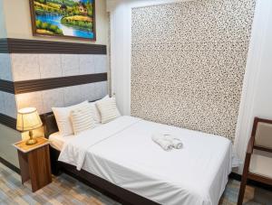 a small bedroom with a white bed and a window at The Canley Boutique Hotel Ortigas Pasig Metro Manila in Manila