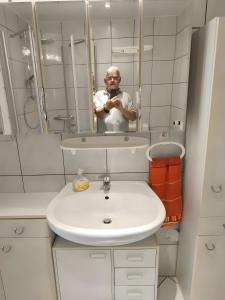 a man taking a picture of himself in a bathroom mirror at Ferienwohnung im Rotkäpchenland in Schwalmstadt +7 photos