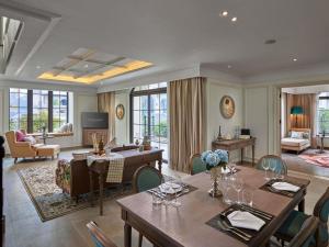 a dining room with tables and chairs and a living room at Grand Mercure Dalat in Da Lat