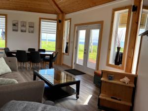 a living room with a couch and a table at Waterfront & breathtaking view - Chalet du Phare in Bonaventure