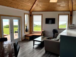 a living room with a couch and a table at Waterfront & breathtaking view - Chalet du Phare in Bonaventure +21 photos