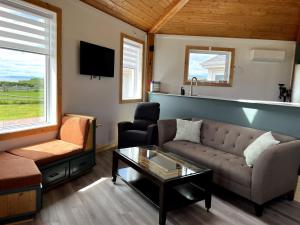 a living room with a couch and a table at Waterfront & breathtaking view - Chalet du Phare in Bonaventure