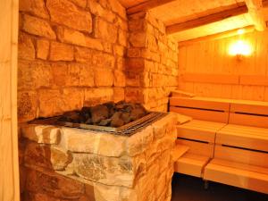 a sauna with a stone wall and a stove at Hotel Traube am See in Friedrichshafen