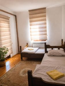 ein Schlafzimmer mit zwei Betten und einem Fenster mit Jalousien in der Unterkunft Sunset Hotel in Plav