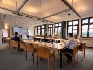 a group of people sitting around a large table in a room at Burghotel Volmarstein in Wetter
