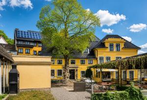 a yellow house with solar panels on the roof at Burghotel Volmarstein in Wetter