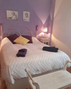 a bedroom with a white bed with purple walls at Oasis Segovia in San Cristóbal de Segovia