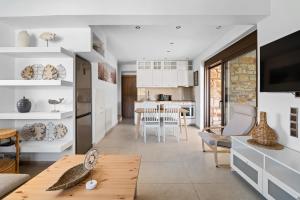 a kitchen and living room with white cabinets at Ιπποθόη in Meganisi