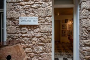 a stone wall with a sign that reads house of system antiquated floor at La Belle Hélène de Ménélas 1862 in Mykines