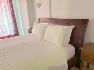 a bedroom with a bed with white sheets and pillows at Stellina Hotel in Skiathos