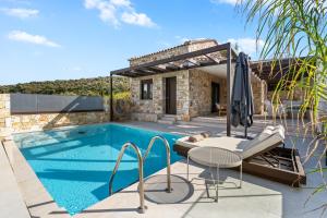 a pool with a table and an umbrella next to a house at Ιπποθόη in Meganisi